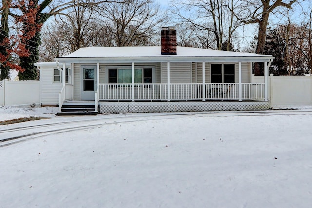 snow covered house featuring covered porch