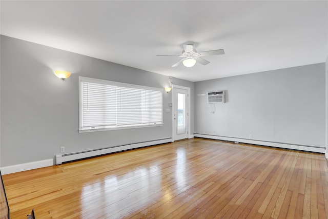 empty room featuring light wood-type flooring, a wall unit AC, ceiling fan, and baseboard heating