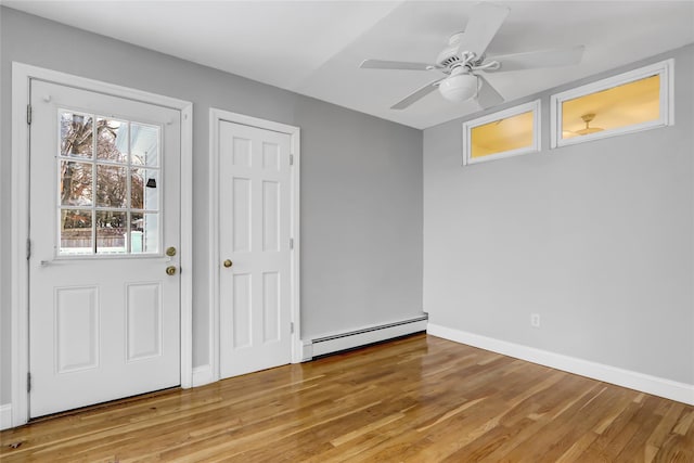 foyer featuring baseboard heating, ceiling fan, and light hardwood / wood-style flooring