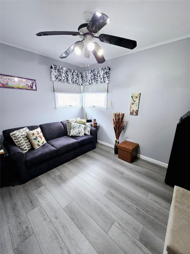 living room featuring crown molding, ceiling fan, and light hardwood / wood-style flooring