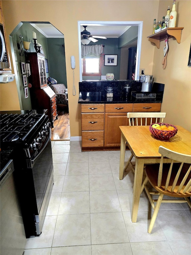 kitchen featuring crown molding, light tile patterned floors, black gas range oven, dishwasher, and ceiling fan