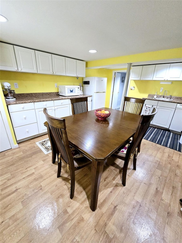 dining room featuring sink and light wood-type flooring