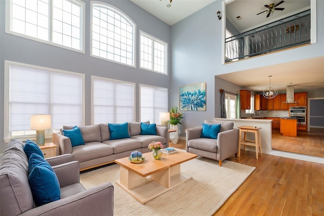 living room with an inviting chandelier, light hardwood / wood-style floors, and a wealth of natural light