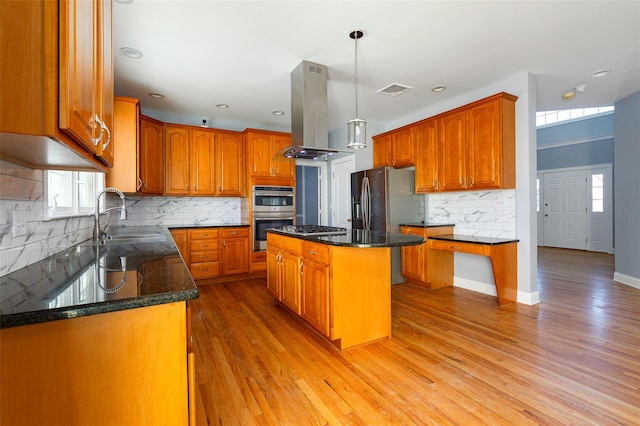 kitchen featuring a kitchen island, decorative light fixtures, dark stone counters, island exhaust hood, and light wood-type flooring