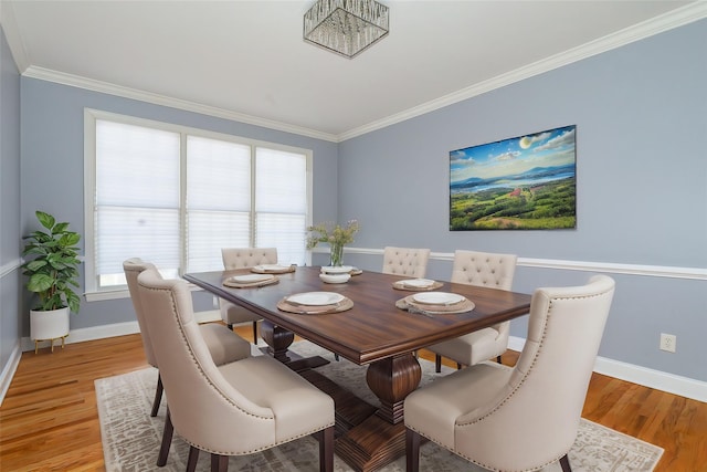 dining space with crown molding and light hardwood / wood-style floors