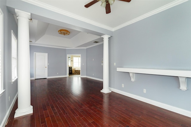 unfurnished living room featuring a tray ceiling, hardwood / wood-style floors, crown molding, and decorative columns