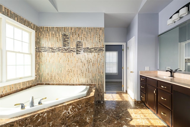 bathroom with vanity, tiled bath, and a wealth of natural light