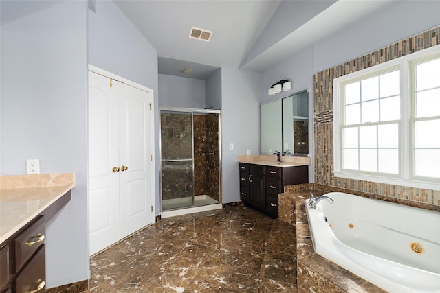 bathroom with lofted ceiling, vanity, and separate shower and tub