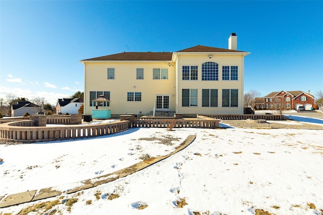 view of snow covered rear of property