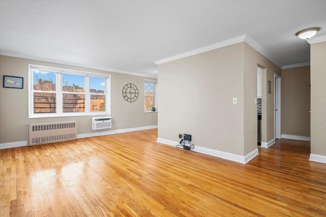 spare room featuring ornamental molding, radiator heating unit, a wall unit AC, and light hardwood / wood-style flooring