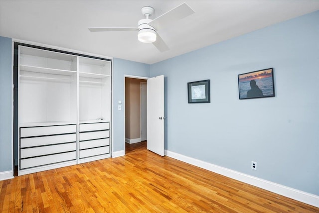 unfurnished bedroom with a ceiling fan, a closet, light wood-style flooring, and baseboards