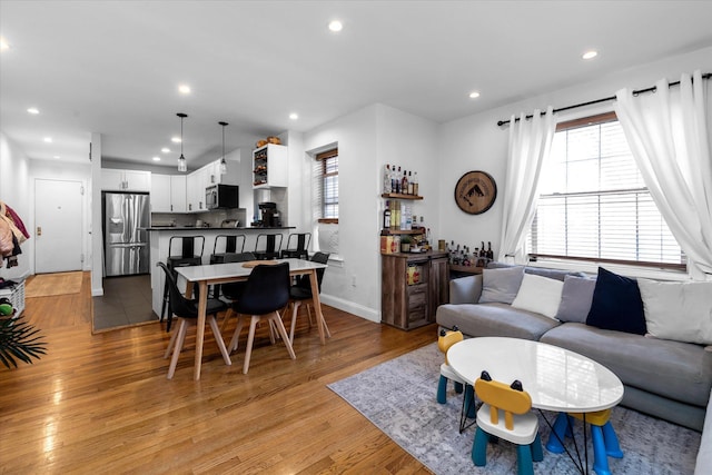 living room featuring bar and light hardwood / wood-style floors