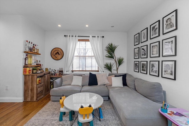 living room featuring indoor bar and light hardwood / wood-style flooring