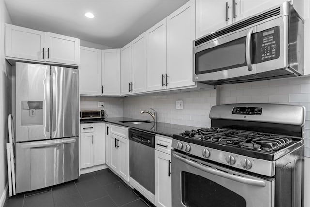 kitchen featuring sink, backsplash, stainless steel appliances, and white cabinets