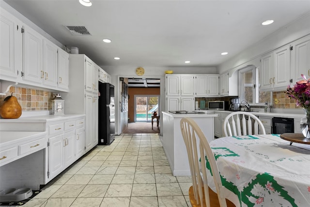 kitchen featuring visible vents, marble finish floor, light countertops, freestanding refrigerator, and stainless steel microwave