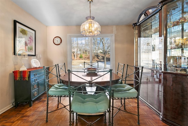 dining room featuring a chandelier and baseboards