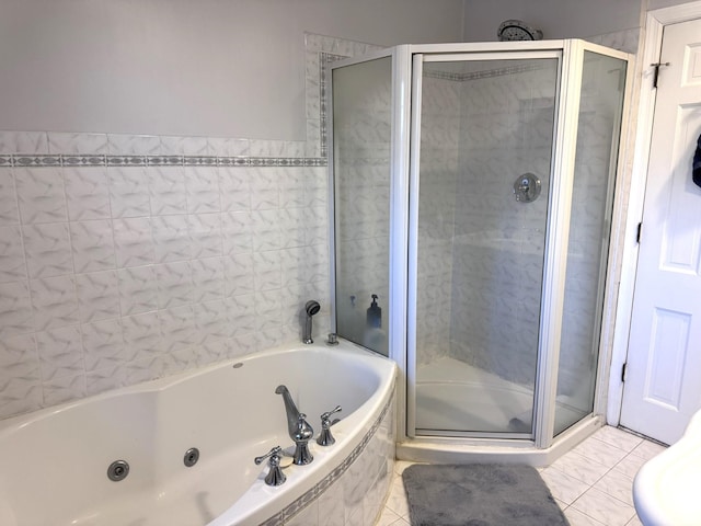 bathroom with a jetted tub, tile patterned flooring, and a shower stall