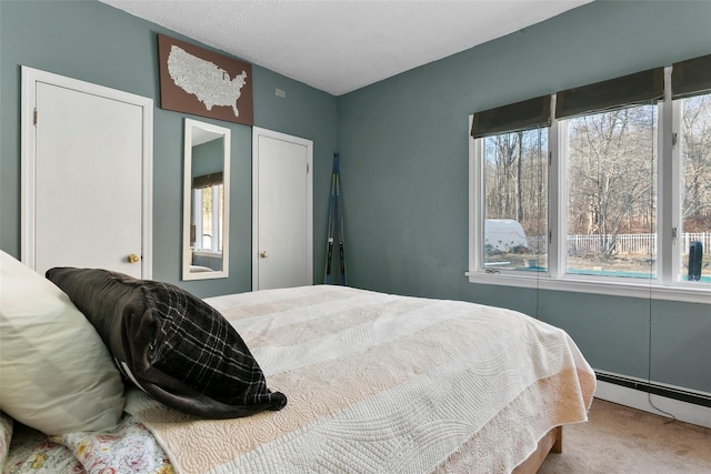 carpeted bedroom with multiple windows and baseboard heating