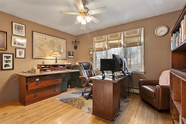 office space with hardwood / wood-style flooring, a baseboard heating unit, and a ceiling fan