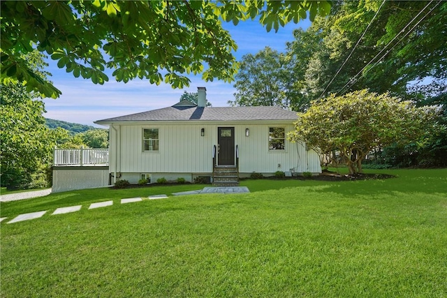 single story home with a front yard, roof with shingles, and a chimney