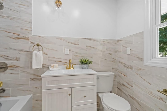 bathroom with toilet, tile walls, and vanity