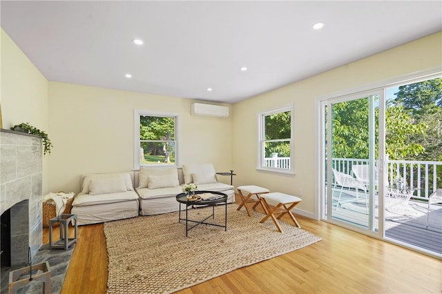 living area with plenty of natural light, recessed lighting, an AC wall unit, and wood finished floors