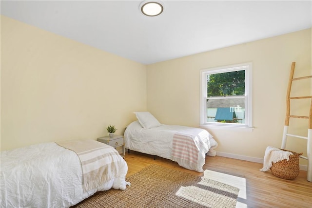 bedroom featuring baseboards and wood finished floors