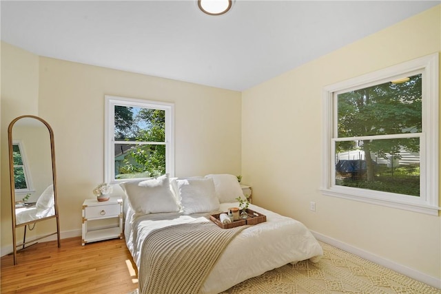 bedroom featuring baseboards and light wood finished floors