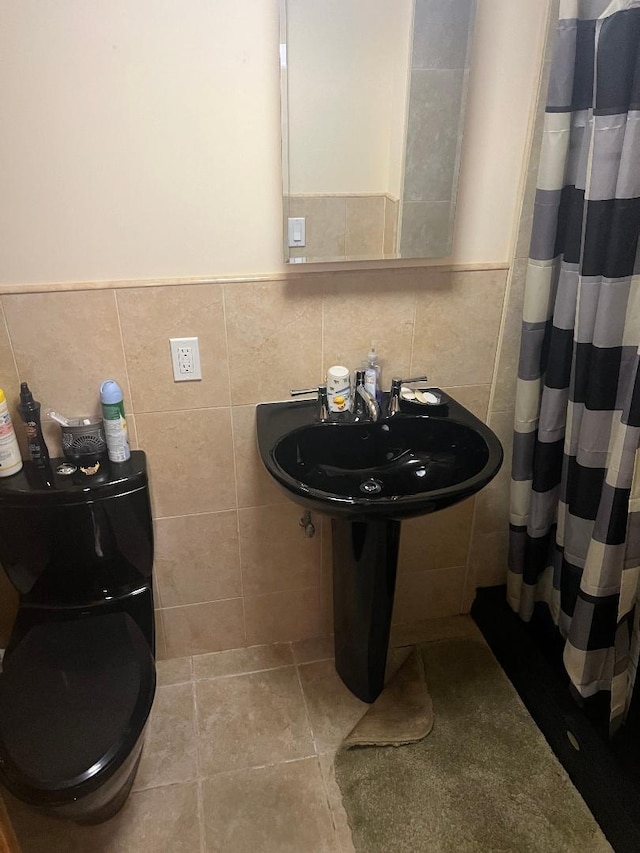 bathroom with tile walls, sink, tile patterned floors, and walk in shower