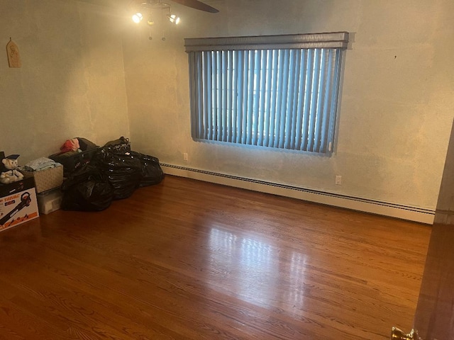 empty room with a baseboard heating unit and hardwood / wood-style flooring