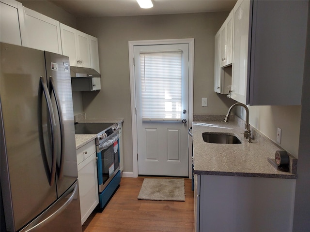 kitchen with white cabinetry, stainless steel appliances, sink, and hardwood / wood-style floors