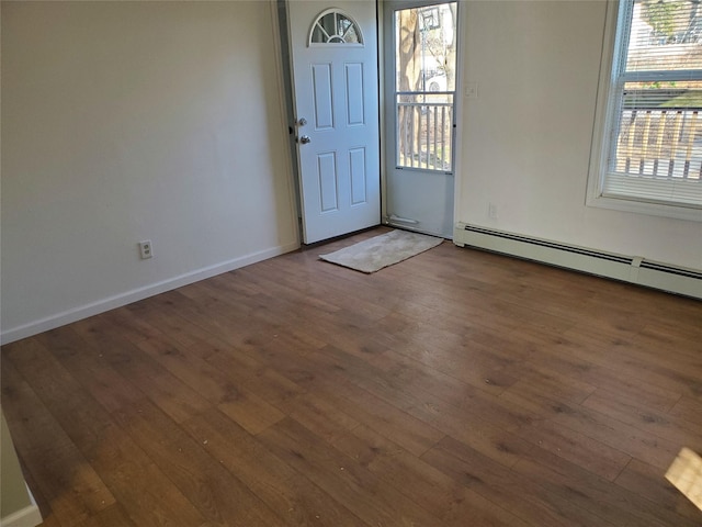 foyer entrance featuring a baseboard radiator and dark hardwood / wood-style floors