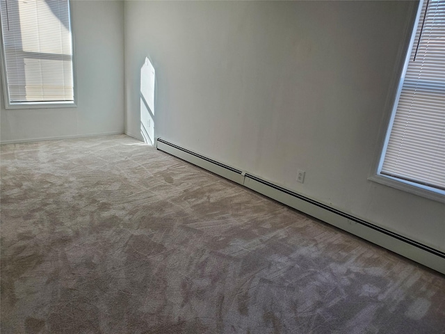 carpeted empty room featuring a baseboard radiator