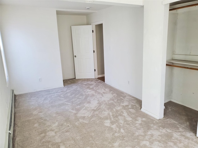 carpeted empty room featuring baseboard heating