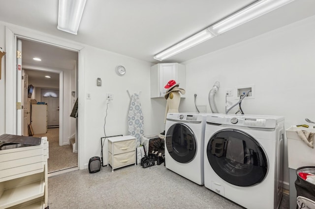 clothes washing area with cabinets and independent washer and dryer