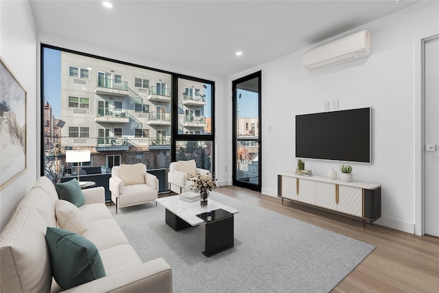 living room with floor to ceiling windows, wood-type flooring, and an AC wall unit