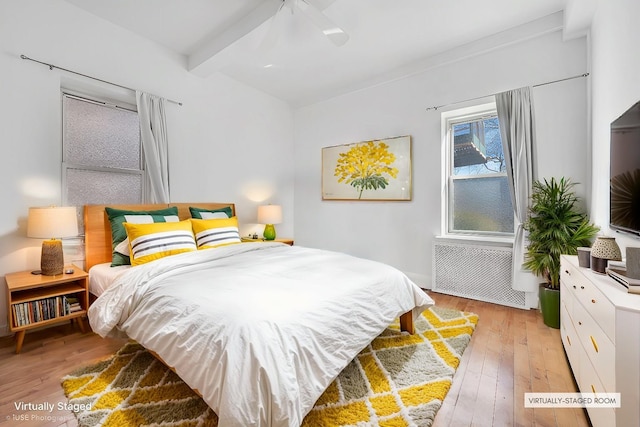 bedroom with radiator, beam ceiling, ceiling fan, and light wood-type flooring