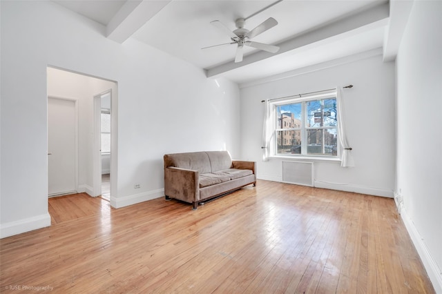 unfurnished room featuring beamed ceiling, ceiling fan, and light hardwood / wood-style floors