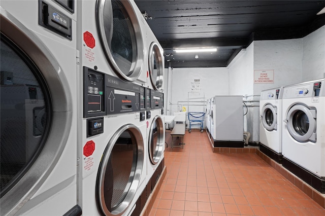 washroom featuring stacked washer and dryer, light tile patterned floors, wooden ceiling, and washer and dryer