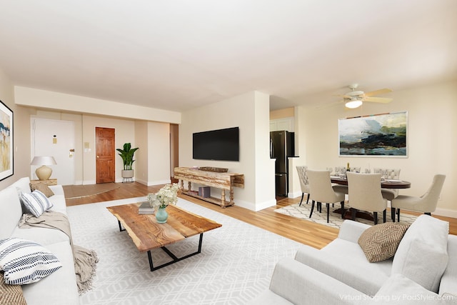 living room featuring ceiling fan and light hardwood / wood-style floors