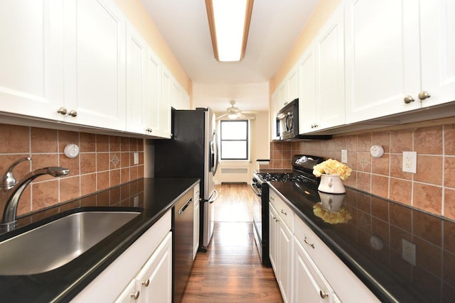 kitchen with sink, white cabinetry, appliances with stainless steel finishes, dark hardwood / wood-style flooring, and backsplash