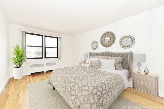 bedroom with hardwood / wood-style floors and radiator heating unit