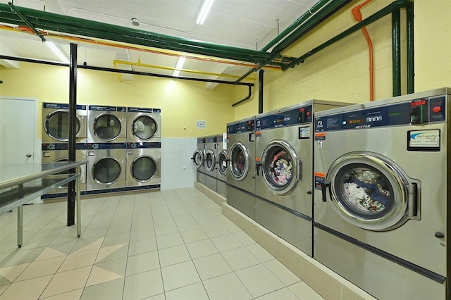 laundry area with stacked washer and dryer, light tile patterned floors, and independent washer and dryer