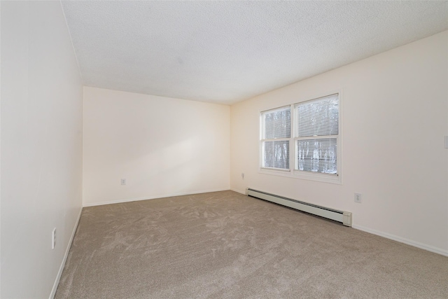 empty room with a textured ceiling, light carpet, and a baseboard heating unit