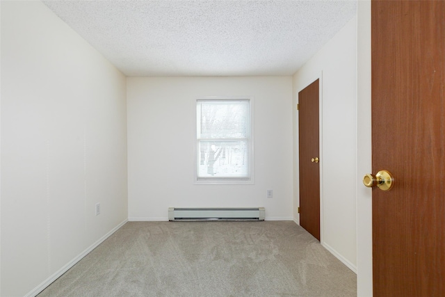 carpeted empty room with a textured ceiling and baseboard heating