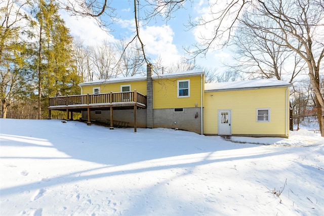 snow covered rear of property featuring a deck