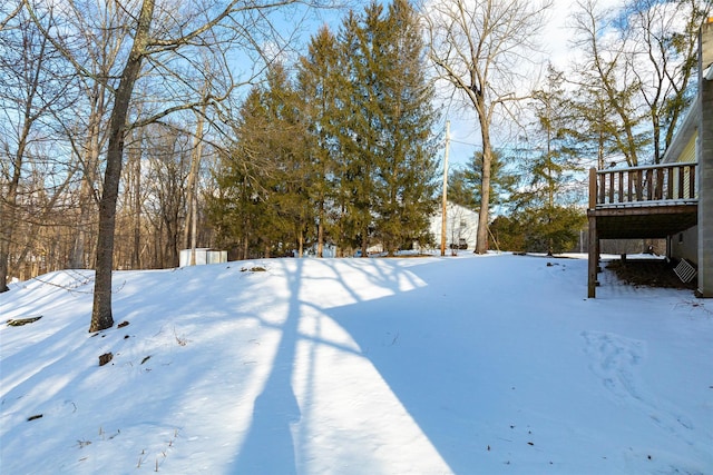 snowy yard featuring a wooden deck