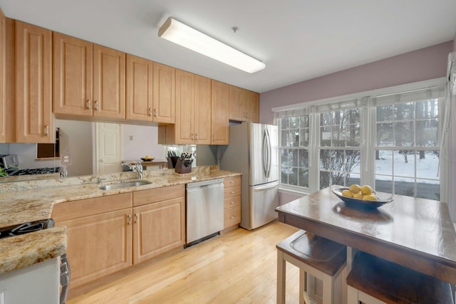 kitchen featuring light stone counters, light brown cabinets, and appliances with stainless steel finishes