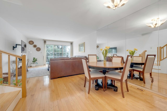 dining space with hardwood / wood-style floors and a chandelier