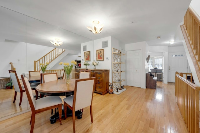 dining space with an inviting chandelier and light hardwood / wood-style floors